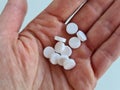 Hands with antibacterial medicine and white pills closeup