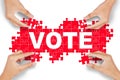 Hands arrange puzzle with vote text Royalty Free Stock Photo
