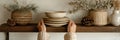 Hands Arranging Handmade Ceramic Plates on a Rustic Wooden Shelf With Decorative Elements in a Cozy Indoor Setting Royalty Free Stock Photo