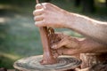 Hands of a artisan creating new clay shape from brown clay