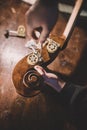 Hands of artisan luthier varnishing, building a double bass