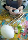 Hands of the artist paint Easter eggs. Royalty Free Stock Photo