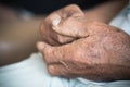 Hands Asian elderly man grasps his hand, older wrinkled hands in prayer sitting alone in his house, World Kindness Day concept and