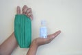 Hands of an Asian girls showing a masker and a bottle of hand sanitizer on her hands