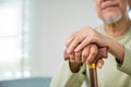 Hands of Asian Old man sitting resting at home hold wooden walking cane Royalty Free Stock Photo