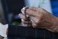 Hands of Asian senior woman holding rosary on bible book. A spiritual grandmother praying rosary closeup, The Catholic symbol. Royalty Free Stock Photo