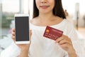 Hands of Asian woman show mobile phone with blank screen for copy space, advertisement while holding credit card. Close up. Royalty Free Stock Photo