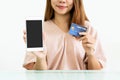 Hands of Asian woman show mobile phone with blank screen for copy space  advertisement while holding credit card. Close up. Royalty Free Stock Photo