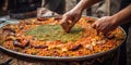 Hands assemble a array of ingredients to create a mouthwatering, traditional paella dish, reflecting the rich culinary