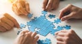 Hands assembling blue jigsaw puzzle on white surface teamwork concept Royalty Free Stock Photo