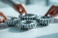 Hands assembling interconnected metal gears symbolizing teamwork and collaboration in mechanical engineering or industrial Royalty Free Stock Photo