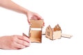 Hands assembling a wooden toy house Royalty Free Stock Photo