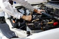 Hands of auto mechanic man with wrench repairing engine of motor under car hood. Insurance concept. Royalty Free Stock Photo