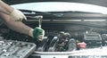 Hands of an auto mechanic with a socket wrench in the engine compartment of a car during repairs Royalty Free Stock Photo