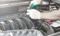 Hands of an auto mechanic with a socket wrench in the engine compartment of a car during repairs Royalty Free Stock Photo