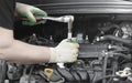 Hands of an auto mechanic with a socket wrench in the engine compartment of a car during repairs Royalty Free Stock Photo