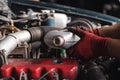 Vehicle mechanic filling oil lubricant into engine of car during routine service maintenance Royalty Free Stock Photo