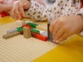 Hands of a baby playing colorful interlocking plastic bricks