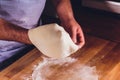 Hands of the Baker knead layer of dough, isolated on black background.