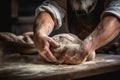 hands of a baker kneading dough on table with flour