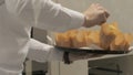 Hands baker putting on tray muffins in paper wrap at bakery shop