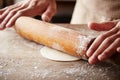 Hands baking dough with rolling pin