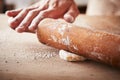 Hands baking dough with rolling pin