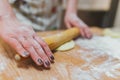 Hands baking dough with rolling pin on wooden table Royalty Free Stock Photo