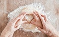 .Hands, baking and heart shape with a girl and grandmother learning how to bake in the kitchen of their home together Royalty Free Stock Photo