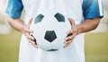 Hands, ball and soccer player ready for sports match, game or competition on the outdoor field. Hand holding round