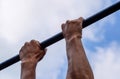 Hands on the bar close-up. The man pulls himself up on the bar. Playing sports in the fresh air. Royalty Free Stock Photo