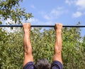 Hands on the bar close-up. The man pulls himself up on the bar. Royalty Free Stock Photo