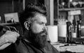 Hands of barber with clipper and comb, close up. Hipster bearded client getting hairstyle. Barbershop concept. Man with