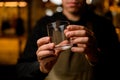 hands of bartender gently hold cocktail glass. Focus on the fingers