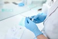 Hands of the beautician in blue gloves holding syringe. The cosmetologist prepares for a injection cosmetology procedure Royalty Free Stock Photo