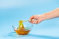 Hands of beautician holding wooden stick and bowl with sugaring paste, close-up. Epilation and body care concept.