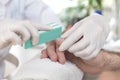 Hands of a beautician in rubber gloves sawing the nails in a man`s hand during a manicure treatment