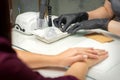 Hands in black gloves of manicurist preparing special nail file equipment for manicure treatment in a beauty salon.