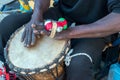 Hands of a black man playing a traditional drum.