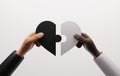 Hands of black man and woman couple holding black and white jigsaw puzzle