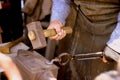Hands of a blacksmith artisan with a hammer. Royalty Free Stock Photo