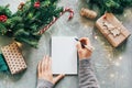 Hands on blank form write Christmas wish list.