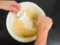 Hands blending flour into a bake mixture