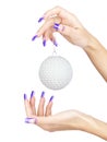 Hands with blue french false acrylic nails manicure holding perl christmas ball