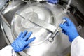 Hands in blue gloves opening industrial process tank Royalty Free Stock Photo