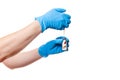 Hands in blue medical gloves are holding a glass bottle with a vaccine different pills.