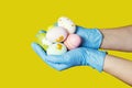 Hands in blue medical gloves holding painted easter eggs. Easter time in quarantine concept. Concept of Easter holyday during Royalty Free Stock Photo