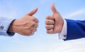 Hands on blue sky background. Male hands show thumbs up sign. Success and approval concept. Gesture expresses approval Royalty Free Stock Photo