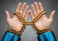 Hands bound by heavy gold chain symbolize restriction, wealth, and inescapable burdens Royalty Free Stock Photo