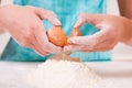 Hands breaking egg into flour Royalty Free Stock Photo